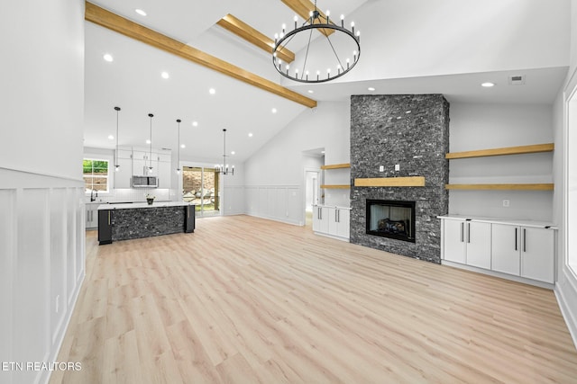 113 Nuhya Way, Loudon, TN 37774 - unfurnished living room featuring a chandelier, beam ceiling, light wood finished floors, recessed lighting, and a fireplace
