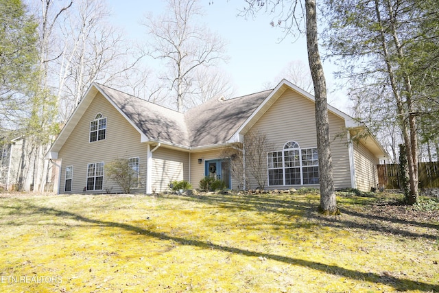 back of house featuring a lawn and fence