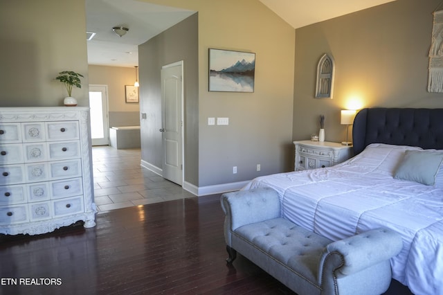 bedroom featuring vaulted ceiling, wood finished floors, and baseboards