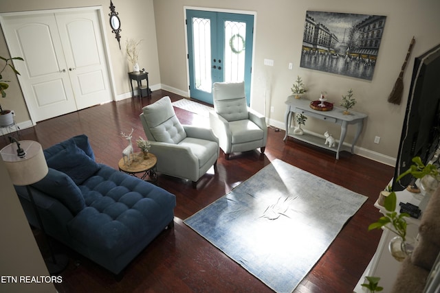 living area featuring french doors, baseboards, and wood finished floors