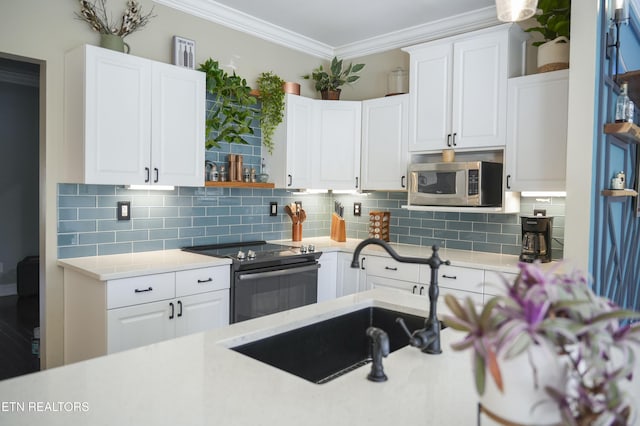 kitchen with black range with electric stovetop, ornamental molding, a sink, stainless steel microwave, and light countertops