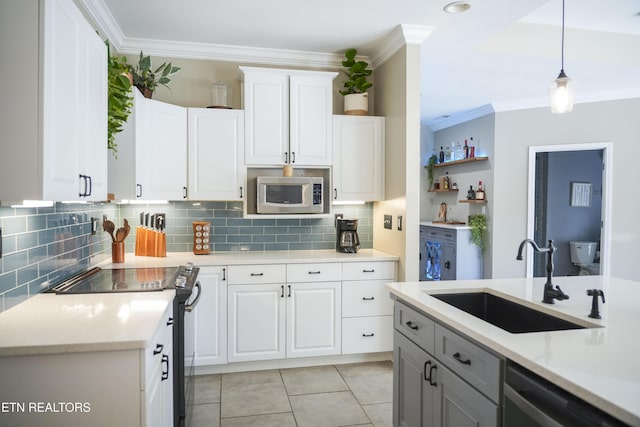 kitchen with a sink, stainless steel appliances, white cabinets, crown molding, and light countertops