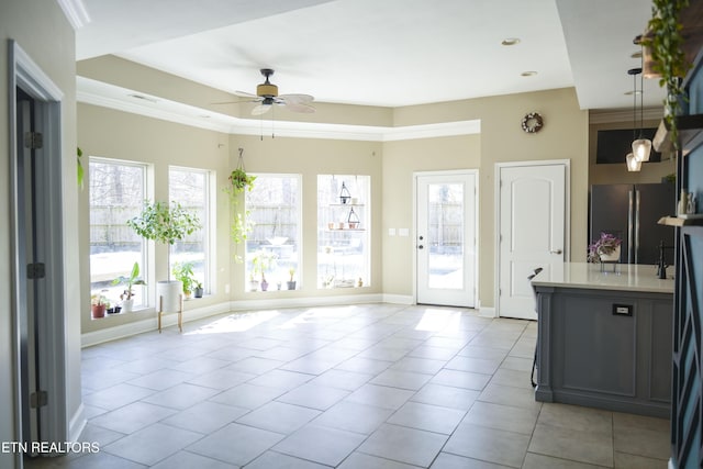 kitchen with baseboards, light countertops, light tile patterned floors, freestanding refrigerator, and a ceiling fan