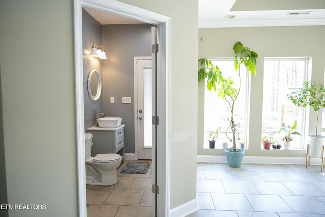 bathroom with vanity, visible vents, baseboards, tile patterned flooring, and toilet