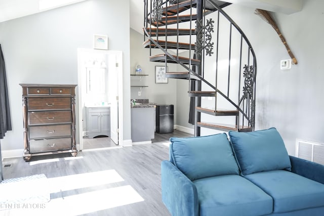 stairway featuring wood finished floors, visible vents, and baseboards