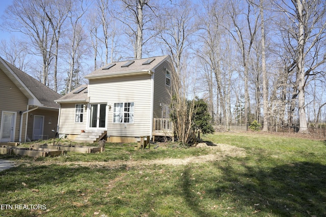 exterior space with entry steps, roof with shingles, a yard, and fence