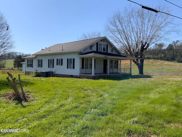 rear view of house with crawl space, a yard, a porch, and central AC