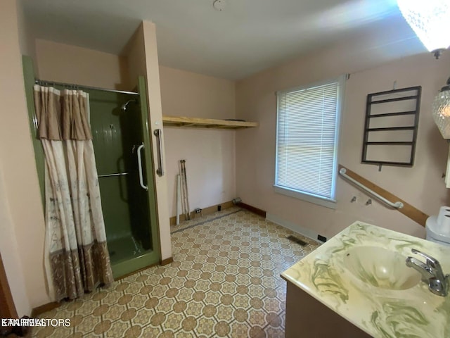 full bath with a shower stall, vanity, and baseboards