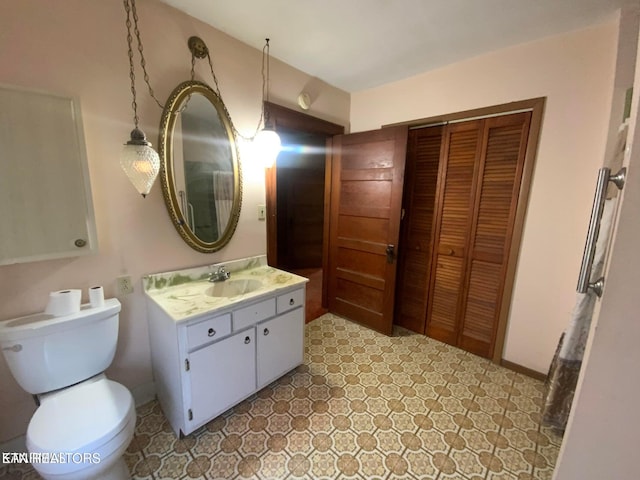 bathroom with baseboards, toilet, and vanity