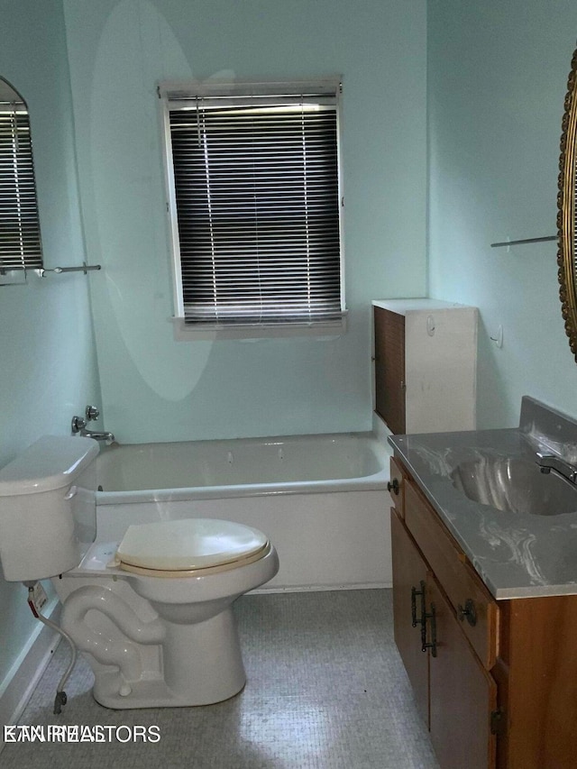 bathroom with toilet, a tub to relax in, and vanity