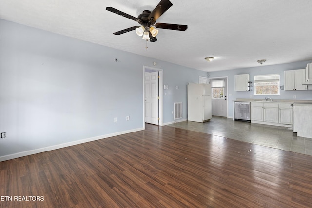 unfurnished living room with a ceiling fan, baseboards, visible vents, a sink, and dark wood-type flooring