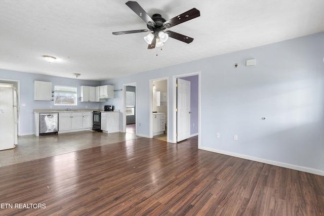 unfurnished living room with dark wood finished floors, ceiling fan, baseboards, and a sink