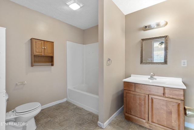 bathroom with baseboards, toilet, vanity, and a textured ceiling