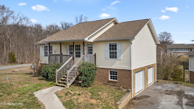 view of front of home with brick siding, stairway, a porch, driveway, and an attached garage