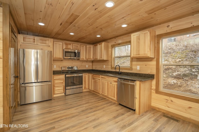 kitchen with dark countertops, wood ceiling, light brown cabinets, and stainless steel appliances