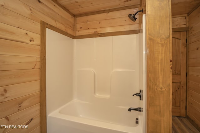 bathroom with  shower combination, wood ceiling, and wood walls