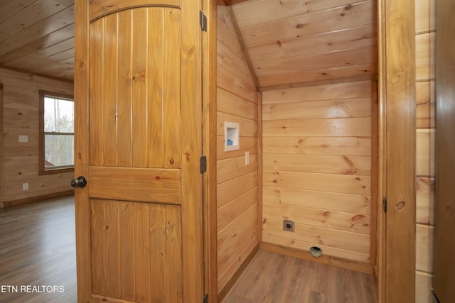 interior space featuring wooden ceiling, wooden walls, and wood finished floors