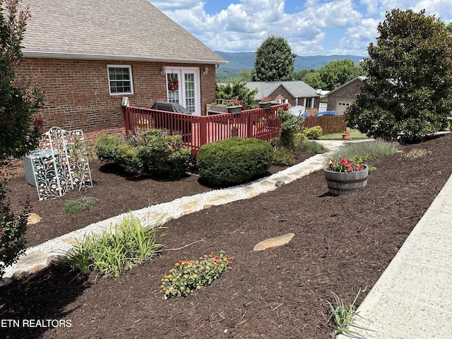 view of yard featuring a deck with mountain view