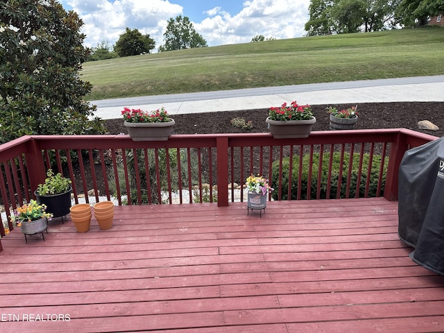 deck featuring grilling area and a lawn