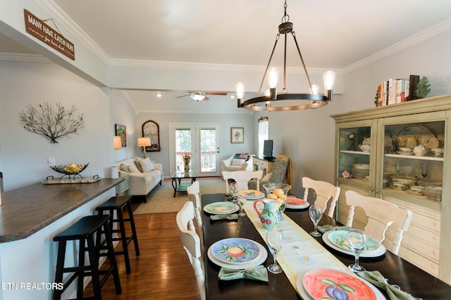 dining room featuring ceiling fan with notable chandelier, dark wood-style flooring, and ornamental molding