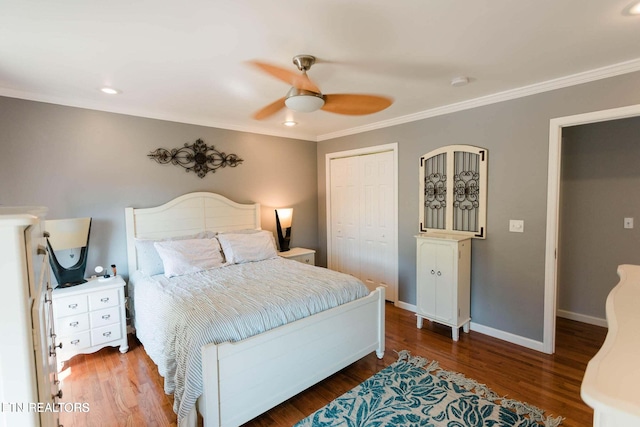 bedroom featuring a closet, baseboards, wood finished floors, and ornamental molding