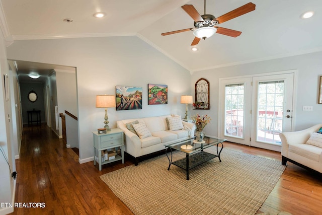 living room featuring lofted ceiling, wood finished floors, baseboards, and ornamental molding