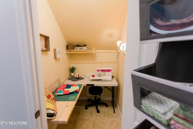 office area with tile patterned floors and vaulted ceiling