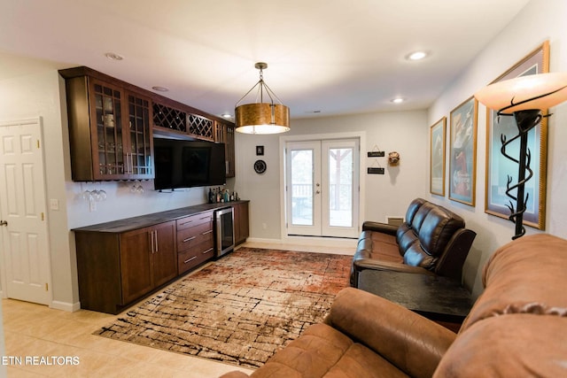 living area featuring french doors, baseboards, beverage cooler, and light tile patterned floors
