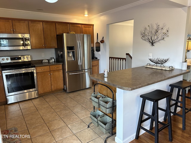 kitchen featuring brown cabinets, dark countertops, and stainless steel appliances