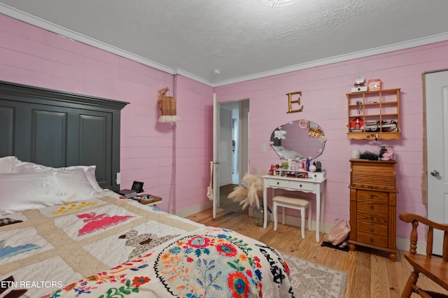 bedroom featuring a textured ceiling, crown molding, and light wood-style floors