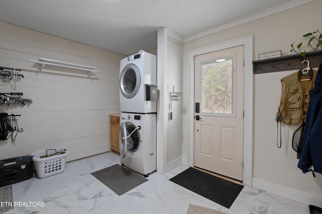 washroom featuring laundry area, stacked washer and clothes dryer, marble finish floor, and wood walls