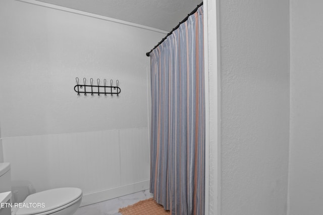 bathroom featuring a shower with curtain, lofted ceiling, toilet, and marble finish floor