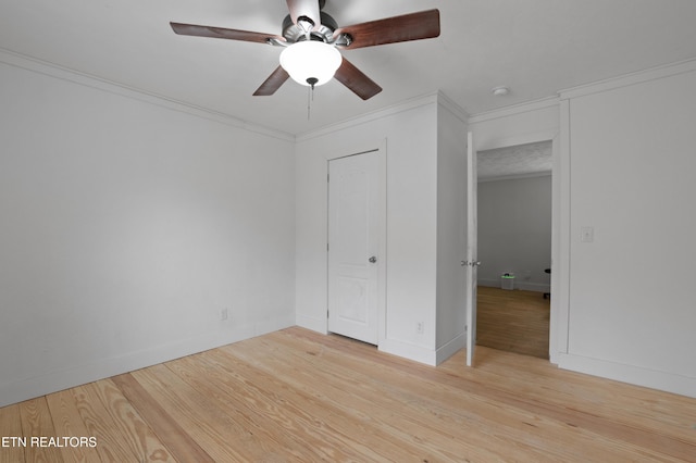 unfurnished bedroom featuring a ceiling fan, light wood-style floors, baseboards, and ornamental molding