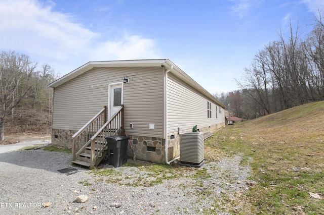 rear view of house with crawl space, entry steps, and central AC