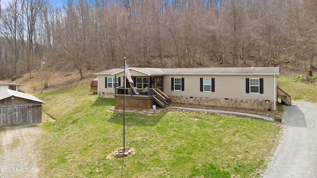 view of front facade featuring gravel driveway, a front lawn, an outdoor structure, and crawl space