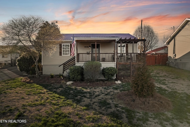 bungalow featuring metal roof, a yard, and covered porch