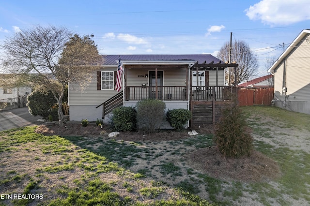 bungalow-style house featuring covered porch, metal roof, and a front yard