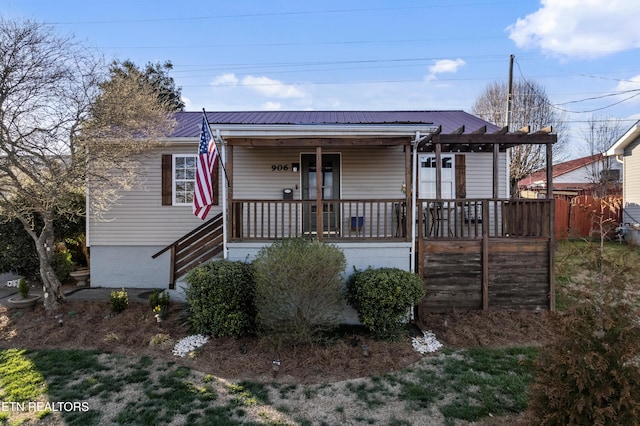 view of front of home featuring metal roof and a porch