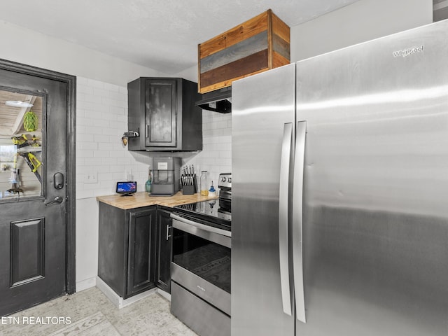 kitchen with under cabinet range hood, stainless steel appliances, dark cabinets, and light countertops