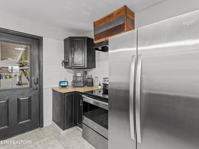 kitchen with decorative backsplash, dark cabinetry, under cabinet range hood, and stainless steel appliances