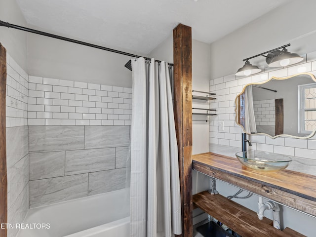 bathroom featuring a sink, shower / bath combo with shower curtain, and backsplash