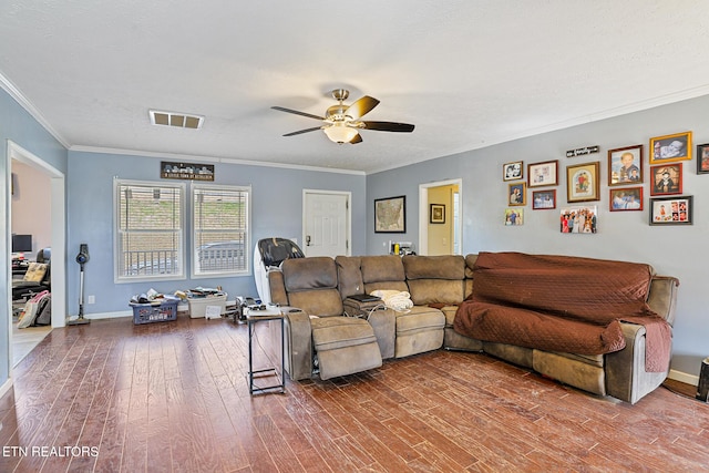 living room with visible vents, crown molding, baseboards, ceiling fan, and wood finished floors