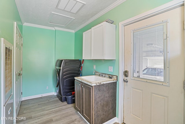 laundry room featuring visible vents, attic access, ornamental molding, light wood-style floors, and a sink