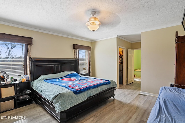 bedroom featuring baseboards, a textured ceiling, crown molding, and light wood finished floors