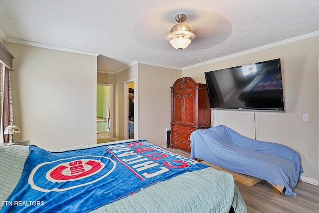 bedroom with a textured ceiling, wood finished floors, and ornamental molding