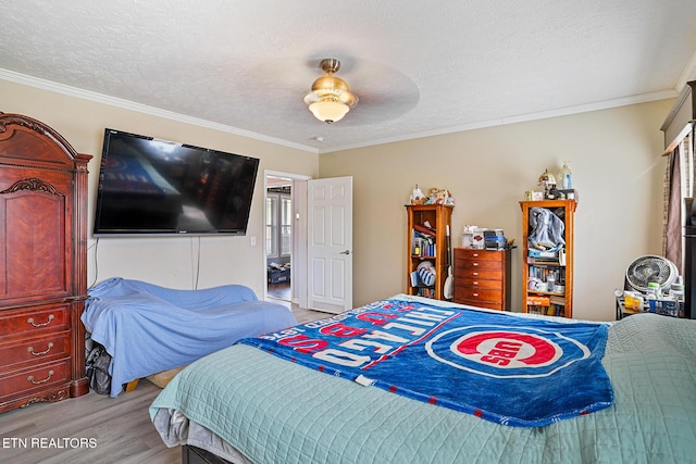 bedroom with crown molding, a textured ceiling, light wood-type flooring, and ceiling fan