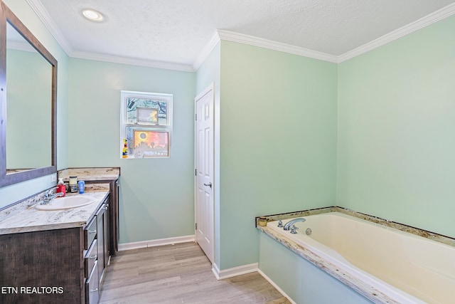 bathroom with vanity, wood finished floors, baseboards, a textured ceiling, and a bath