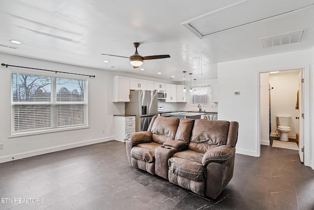 living area with visible vents, recessed lighting, attic access, and baseboards