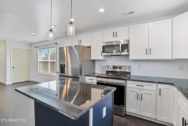 kitchen with decorative light fixtures, stainless steel appliances, white cabinets, and dark stone counters