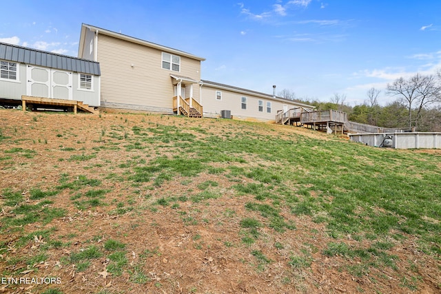 rear view of house featuring a yard, a shed, entry steps, and an outdoor structure